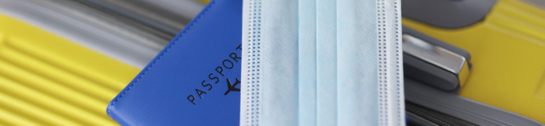 protective-face-mask-with-passport-lying-yellow-suitcase-closeup-flight-rules-during-covid